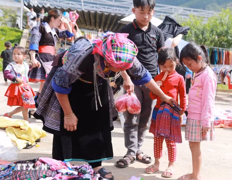 3. El mercado no es solo para adultos, sino también una alegría para los niños, quienes disfrutan ir allí y que sus madres les compren ropa nueva. (Foto: VNA)
