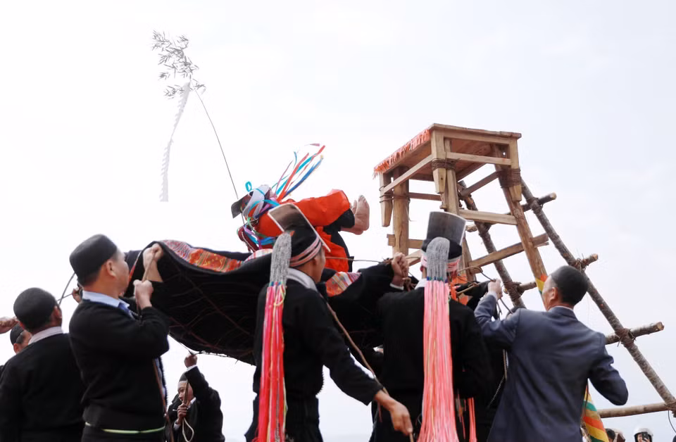 Bajo la guía del chamán, el joven se abraza las rodillas y se deja caer libremente, simbolizando su transformación en un adulto. (Foto: VNA)