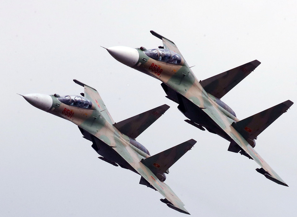 Los Su30-MK2 inclinan sus alas al pasar sobre las gradas para saludar a los delegados presentes en la ceremonia. (Foto: VNA)