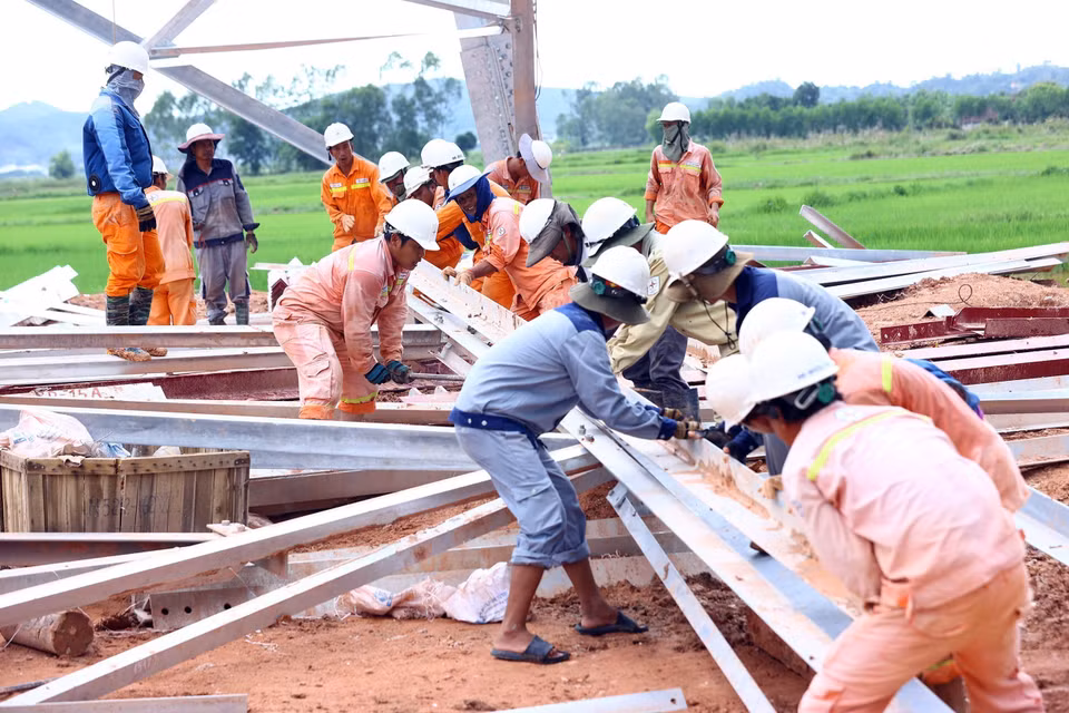 Trabajadores del grupo PTC4 trabajan en el poste 360 en Nghi Loc, Nghe An, en el tramo Quang Trach - Quynh Luu. (Foto: VNA)