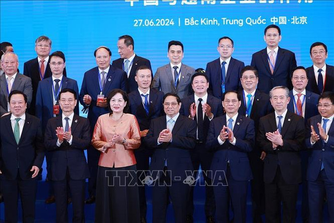 El primer ministro de Vietnam, Pham Minh Chinh (cuarta persona desde la izquierda, primera fila) y delegados participantes en la cita. (Fuente: VNA) vna_potal_thu_tuong_du_hoi_nghi_hop_tac_viet_nam_-_trung_quoc_ve_phat_trien_ha_tang_chien_luoc_giao_thong_stand_(1).jpg