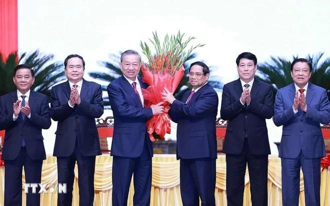 El miembro del Buró Político y primer ministro, Pham Minh Chinh, en nombre de los altos dirigentes del Partido y del Estado, entrega flores para felicitar al compañero To Lam por su elección como secretario general del Comité Central del PCV del XIII mandato. (Foto: VNA) to-lam-pham-minh-chinh-6383.jpg.webp