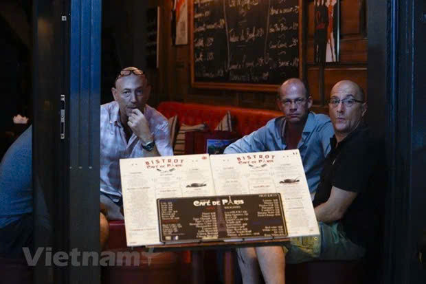 Turistas extranjeros sentados en un puesto de venta de cerveza en el casco antiguo de Hanoi (Foto: VietnamPlus) z5749491243213-b6922b8d2fc35f2fc507981595bd1347-6362.jpg.jpg