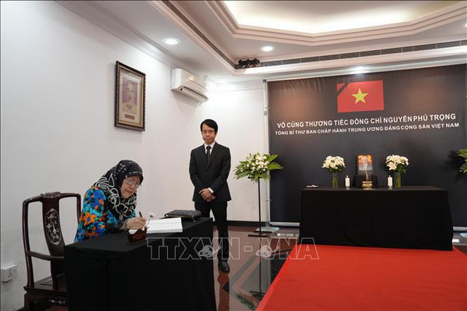 La princesa Hajah Masna escribe en el libro de condolencias. (Fuente: VNA) cong chua.jpg