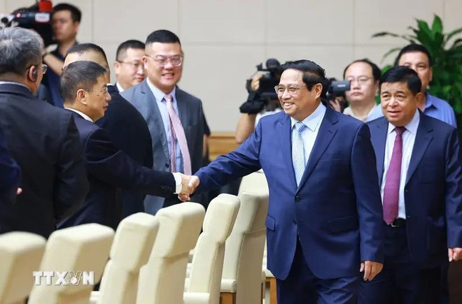 El primer ministro de Vietnam, Pham Minh Chinh (en la derecha), estrecha la mano de empresario chino. (Fuente: VNA) 8.webp