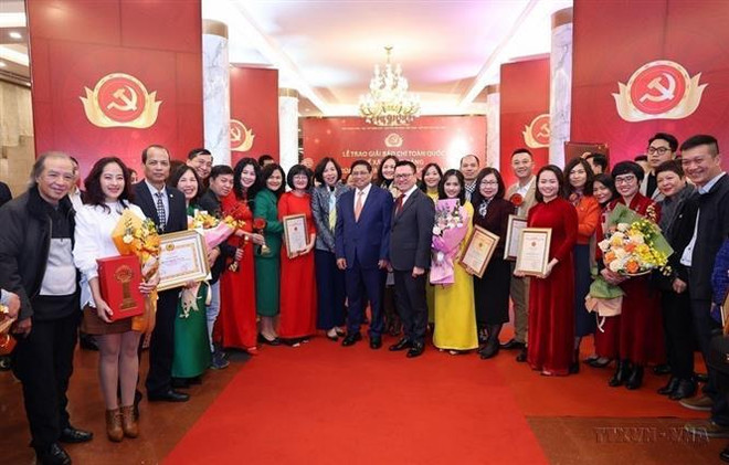 El primer ministro Pham Minh Chinh se toma una fotografía con los periodistas de la Agencia Vietnamita de Noticias que ganan el VIII Premio Nacional de Prensa sobre Construcción del Partido, Bua Liem Vang (Hoz y Martillo de Oro) (Foto: VNA) vna_potal_bao_chi_cach_mang_viet_nam_-__tien_phong_va_doi_moi__7434817.jpg