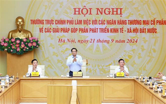 El primer ministro de Vietnam, Pham Minh Chinh (en el medio), en la cita. (Fuente: VNA) vna_potal_thuong_truc_chinh_phu_lam_viec_voi_cac_ngan_hang_tmcp_ve_giai_phap_gop_phan_phat_trien_kinh_te-xa_hoi_7608621 (1).jpg