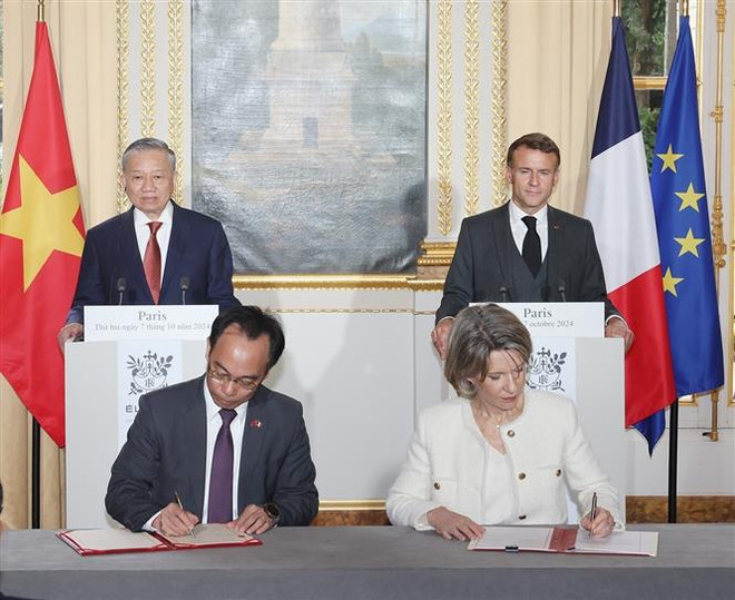 Los dos dirigentes testimonian la firma de documentos de cooperación entre ambos países (Foto: VNA) vna_potal_tong_bi_thu_chu_tich_nuoc_to_lam_cung_tong_thong_phap_hop_bao_va_chung_kien_le_ky_cac_van_kien_hop_tac_7638316.jpg