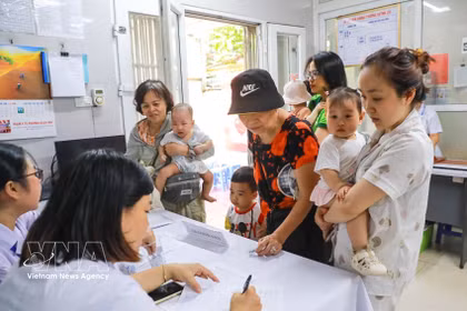 Las familias llevan a sus hijos a recibir vitamina A en la clínica del barrio de Bach Mai, en Hanoi. (Foto: VNA)