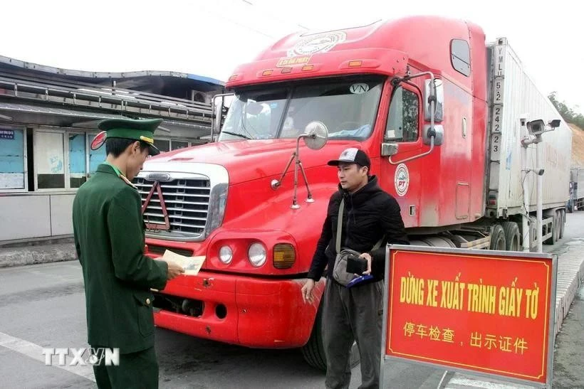 Las autoridades inspeccionan los procedimientos de los operadores de vehículos que transportan mercancías en el puesto fronterizo internacional de Huu Nghi (provincia de Lang Son). (Foto: VNA)