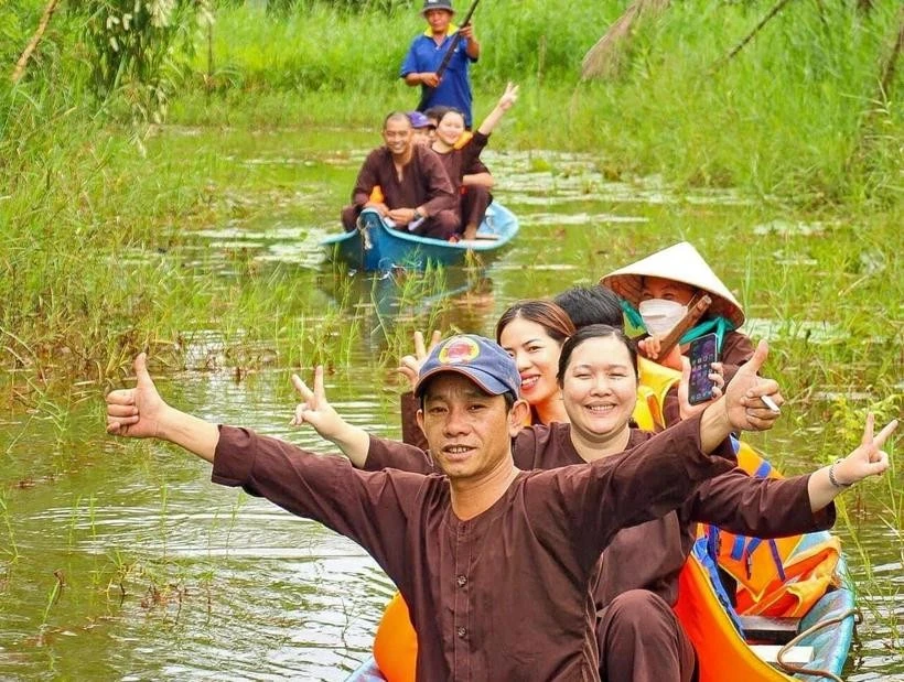Los turistas disfrutan de recorrer el bosque en sampán en el sitio de ecoturismo. (Foto: VNA)