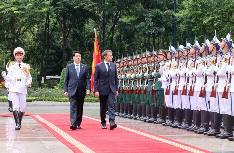 El presidente Luong Cuong (izquierda) y su homólogo francés, Emmanuel Macron, pasan revista a la Guardia de Honor del Ejército Popular de Vietnam. (Foto: VNA)