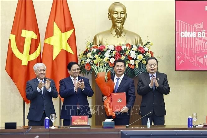 El primer ministro Pham Minh Chinh (segundo desde la izquierda) y el presidente de la Asamblea Nacional, Tran Thanh Man (extrema derecha), presentan la decisión del nombramiento y ofrecen flores a Nguyen Hong Dien. (Foto: VNA)