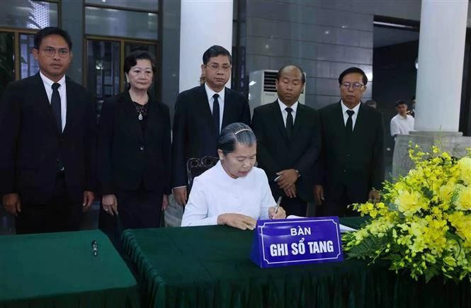 Men Sam An, vicepresidenta del Partido Popular de Camboya, presidenta del Consejo Nacional del Frente de Solidaridad para el Desarrollo de la Patria Camboyana y presidenta de la Asociación de Amistad Camboya-Vietnam, escribe en el libro de condolencias del expresidente estatal Tran Duc Luong. (Foto: VNA)
