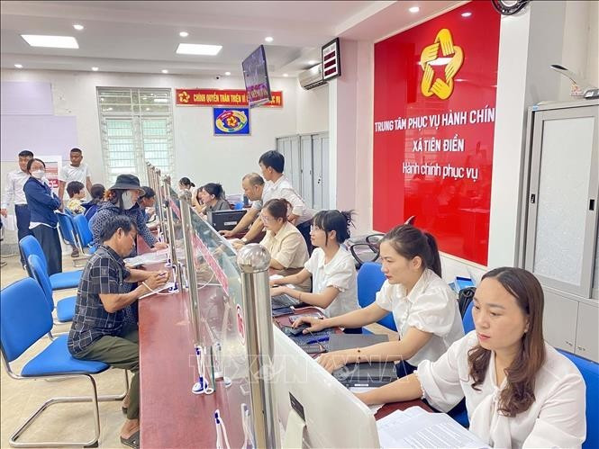 Funcionarios y ciudadanos realizan trámites administrativos en el centro de servicios administrativos públicos de la comuna de Tien Dien, provincia de Ha Tinh. (Foto: VNA)