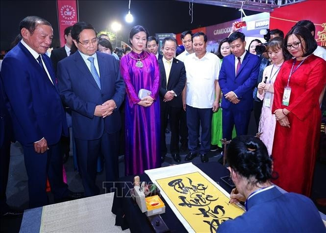 El primer ministro Pham Minh Chinh visita un stand vietnamita en el evento (Foto: VNA)
