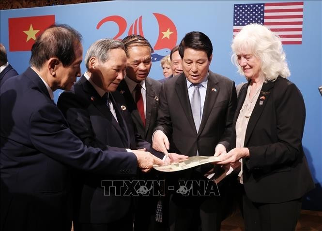 El presidente Luong Cuong (segundo a la derecha) en el intercambio de recuerdos para las familias de los soldados vietnamitas y estadounidenses. (Foto: VNA)