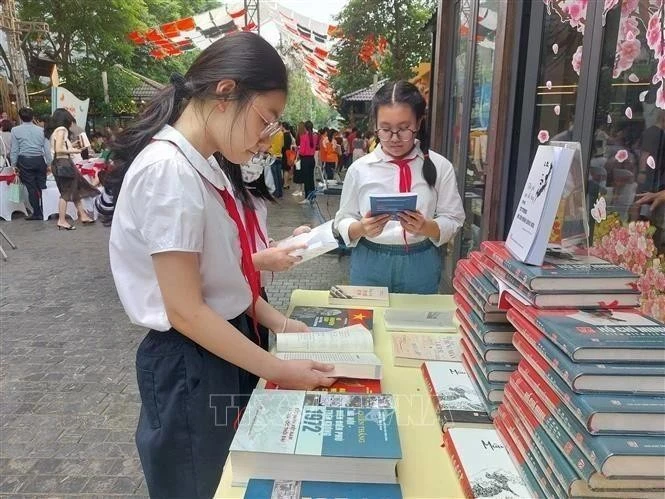 Los estudiantes leen libros en la calle de los libros de Hanoi. (Foto: VNA)