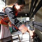 Se trenzan pequeñas y cortas hebras de tela y se estiran para formar hilos largos. Foto: VNA