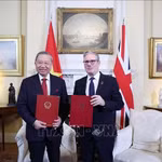 El secretario general To Lam y el primer ministro del Reino Unido, Keir Starmer, intercambian una declaración conjunta sobre la elevación de los nexos bilaterales a una asociación estratégica integral. (Foto: VNA) 