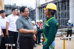 El primer ministro Pham Minh Chinh con los trabajadores que construyen el proyecto del Aeropuerto Internacional de Phu Quoc. (Foto: VNA)