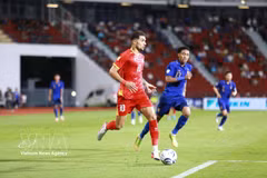 Hoang Hen de Vietnam (n.º 10) intenta avanzar con el balón ante un jugador tailandés.