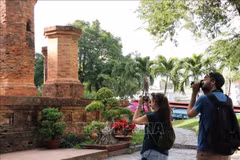 Dos turistas rusos toman fotos con entusiasmo en la reliquia de la Torre Ponagar (Khanh Hoa). (Foto: VNA)