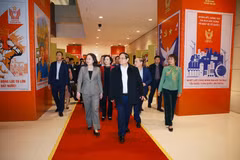 El primer ministro Pham Minh Chinh inspecciona la exposición fotográfica sobre el movimiento de emulación patriótica en diferentes períodos, organizada por la Agencia Vietnamita de Noticias (Fuente: VNA)