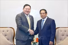 El primer ministro Pham Minh Chinh (der.) recibe a Thammasak Sethaudom, presidente y director ejecutivo de SCG Group. (Foto: VNA)