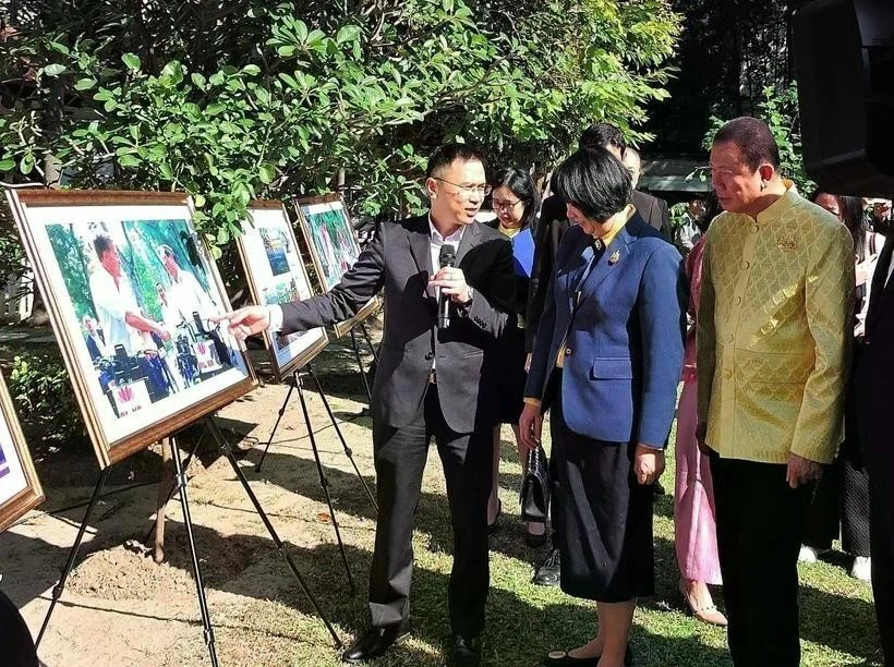 Pham Anh Tuan, director general de la Autoridad del Servicio de Información Exterior del Ministerio de Información y Comunicación (izquierda) y visitantes de la exposición de Bangkok sobre la cultura, la gente y los paisajes de Vietnam. (Foto: VNA)