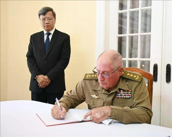 El Teniente General Álvaro López Miera, jefe de las Fuerzas Armadas Revolucionarias de Cuba, escribe en el libro de condolencias de la Embajada de Vietnam en Cuba. (Foto: VNA) cuba.jpg