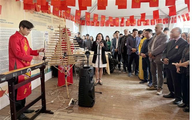 Los visitantes presencian una actuación de instrumentos musicales tradicionales vietnamitas durante el evento. (Foto: VNA) vna-potal-bao-nhan-dan-tham-du-hoi-bao-nhan-dao-tai-phap-8274381.jpg
