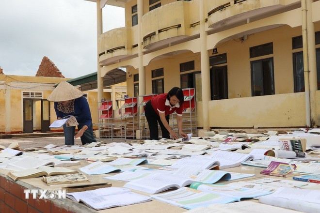 Profesores en la provincia de Ha Tinh aprovechan el sol para secar libros para sus alumnos. (Foto: Hoang Nga/VNA) thu-tuong-1.jpg