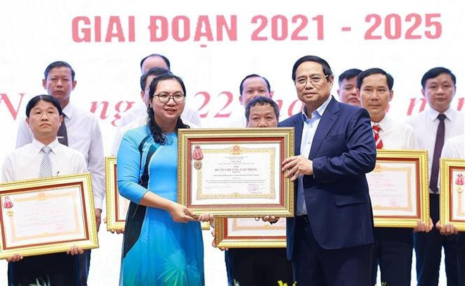 El primer ministro Pham Minh Chinh otorgó la Orden de Trabajo de Tercera Clase a las organizaciones por sus destacados logros en el movimiento de emulación "Todo el país se une para construir nuevas zonas rurales". Foto: VNA vna-potal-thu-tuong-chu-tri-hoi-nghi-toan-quoc-tong-ket-chuong-trinh-muc-tieu-quoc-gia-xay-dung-nong-thon-moi-8106832.jpg