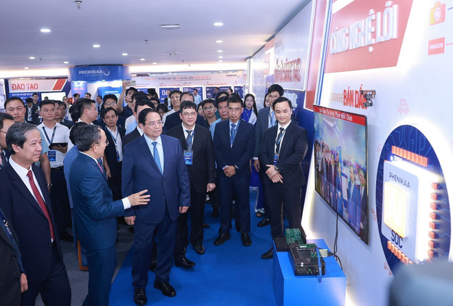 El primer ministro Pham Minh Chinh visita una exposición que muestra los logros de la Universidad de Phenikaa. (Foto: VNA) vna-potal-thu-tuong-du-le-cong-bo-quyet-dinh-chuyen-doi-mo-hinh-dai-hoc-phenikaa-8164230.jpg