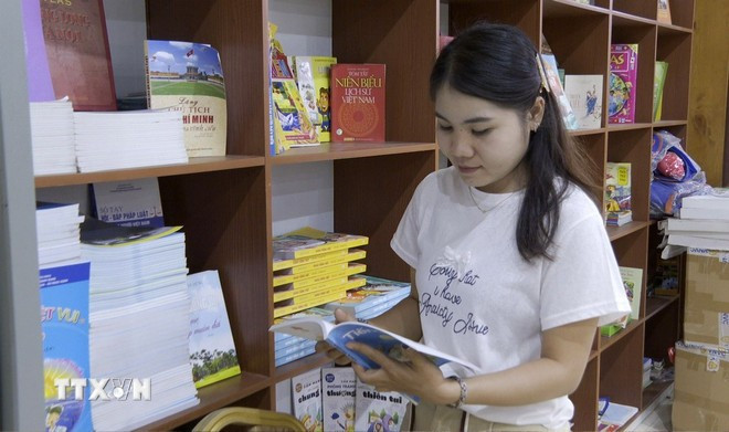 Thatdao Santhavai considera que esta estantería es un tesoro de conocimientos útiles para los estudiantes laosianos. (Foto: VNA) tu-sach-tieng-viet-vientiane-2.jpg