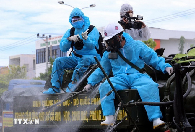 Un reportero de la VNA trabaja desde la parte trasera de un camión rociando desinfectante en zonas de alto riesgo de la pandemia del COVID-19 en Son Tra, ciudad de Da Nang. (Foto: VNA) 0606-thong-tan-xa-11.jpg