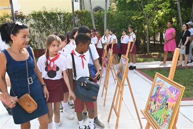 Maestros y alumnos de la Escuela Primaria Vo Thi Thang visitan el espacio donde se exhiben pinturas de niños vietnamitas sobre la relación fraternal entre los pueblos de Vietnam y Cuba. Foto: VNA thumbstand-3.jpg