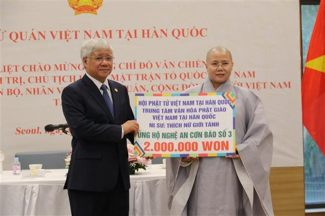 La venerable Thich Nu Gioi Tanh, presidente de la Asociación de Budistas Vietnamitas en la República de Corea, entrega 2 millones de wones (monedas surcoreanas) donados por budistas vietnamitas para ayudar a los residentes de la provincia de Nghe An a superar las consecuencias del tifón Wipha. (Foto: VNA) vna-potal-chu-tich-do-van-chien-tham-dai-su-quan-va-gap-go-ba-con-nguoi-viet-tai-han-quoc-8186644.jpg
