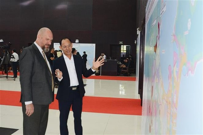 Un representante empresarial vietnamita conversa con un socio extranjero sobre la Zona de Libre Comercio de Da Nang durante la ceremonia. (Foto: VNA) vietnam-establishes-first-free-trade-zone-in-da-nang-2.jpg