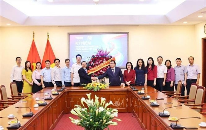 El subjefede la Comisión de Información, Educación y Movilización de Masas del Comité Central del PCV, Lai Xuan Mon, entregó flores para felicitar a los periodistas de VNA. (Foto: VNA) chuc-mung.jpg
