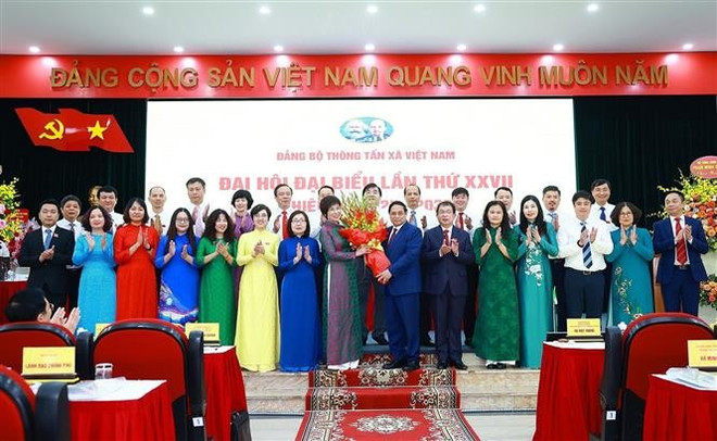 El primer ministro Pham Minh Chinh entrega flores para felicitar al 27.º Buró Ejecutivo del Comité partidista de la Agencia de Noticias de Vietnam por el período 2025-2030. (Fuente: VNA) vna-potal-thu-tuong-du-dai-hoi-dang-bo-thong-tan-xa-viet-nam-lan-thu-27-nhiem-ky-2025-2030-8153965.jpg
