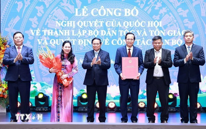 El primer ministro Pham Minh Chinh (tercero, a la izquierda) entrega flores a los líderes del Ministerio de Asuntos Étnicos y Religiosos. (Foto: VNA) bo-dan-toc-va-ton-giao.jpg