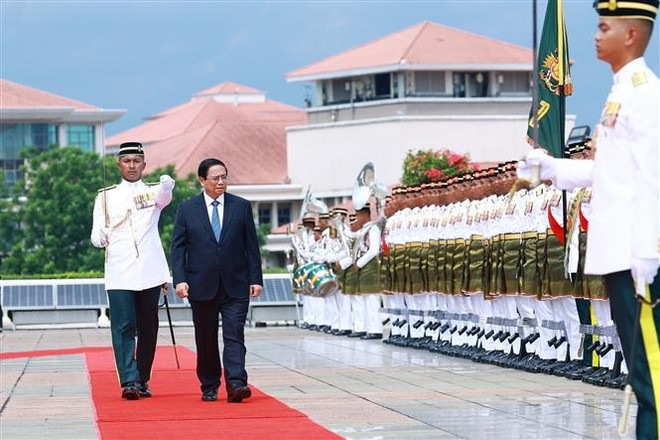 El primer ministro Pham Minh Chinh pasa revista a la guardia de honor en la ceremonia de bienvenida celebrada en Kuala Lumpur (Foto: VNA) vna-potal-le-don-thu-tuong-pham-minh-chinh-va-phu-nhan-tham-chinh-thuc-malaysia-8053204.jpg