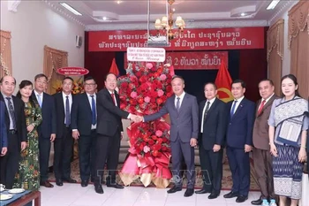 El subsecretario permanente del Comité del Partido de Ciudad Ho Chi Minh, Nguyen Ho Hai, (en el centro a la izquierda), entrega flores para felicitar al cónsul general adjunto de Laos, Amphay Souvannasen. (Fuente: VNA)