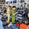 Las autoridades inspeccionan y confiscan una gran cantidad de productos de origen desconocido en una tienda (Foto: VNA)
