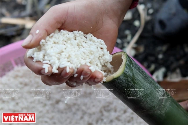 El arroz pegajoso se empapa en agua durante 6 a 8 horas antes de ser puesto en tubos de bambú. (Fuente: VNA)