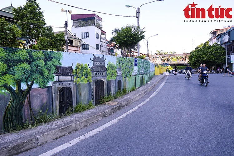 Las pinturas vívidas y coloridas representan la historia, la gente y las fiestas culturales tradicionales de la ciudad de Hanoi, lo que capta la atención especial de las personas cuando llegan o pasan por el lugar. (Fuente:VNA)