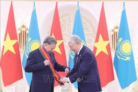 El presidente kazajo, Kassym-Jomart Tokayev (derecha), entrega la Orden de Dostyk de Primera Clase al secretario general del Partido Comunista de Vietnam, To Lam. (Foto: VNA)
