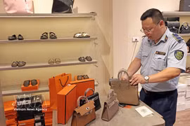 Un oficial inspecciona un establecimiento comercial en la calle Hang Dao, en Hanoi. (Foto: VNA)